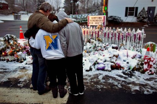 Members of the Rutter family of Sandy Hook, Conn., embrace early Christmas morning as they stand near memorials by the Sandy Hook firehouse in Newtown, Conn.,Tuesday, Dec. 25, 2012. People continue to visit memorials after gunman Adam Lanza walked into Sandy Hook Elementary School in Newtown, Conn., Dec. 14, and opened fire, killing 26, including 20 children, before killing himself. (AP Photo/Craig Ruttle)