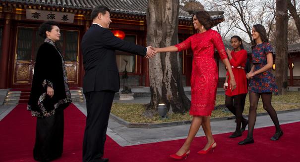 U.S. first lady Michelle Obama, third from right, her daughters Malia, right, and Sasha, second from right, is greeted by Chinese President Xi Jinping, second from left, and his wife Peng Liyuan, left, at the Diaoyutai State guest house in Beijing, China Friday, March 21, 2014. U.S. first lady Michelle Obama met with excited students who were building robots and tried her hand at Chinese calligraphy Friday during a tour of a Beijing high school. (AP Photo/Andy Wong, Pool)